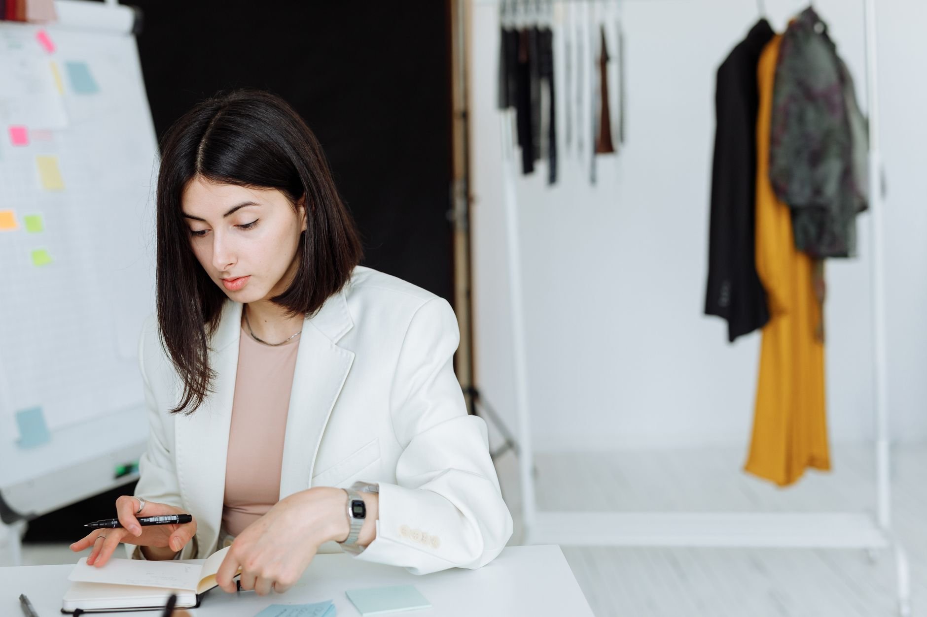 Young founder writing notes in a modern workspace, planning business strategy